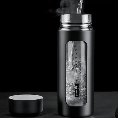 Modern black and amber insulated glass water bottle with matte finish silver lid and transparent window showing glass water inside