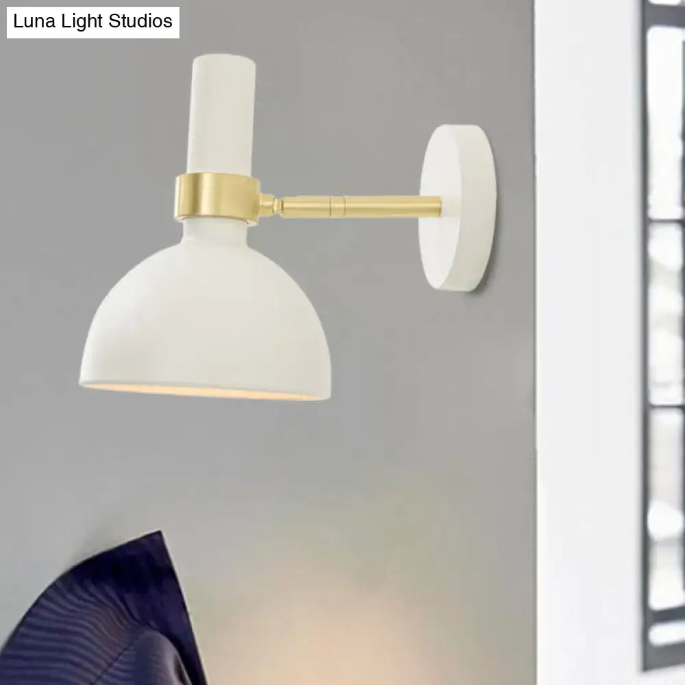Modern black and brass domed wall lamp with white matte finish and gold-toned arm for bedroom bedside use