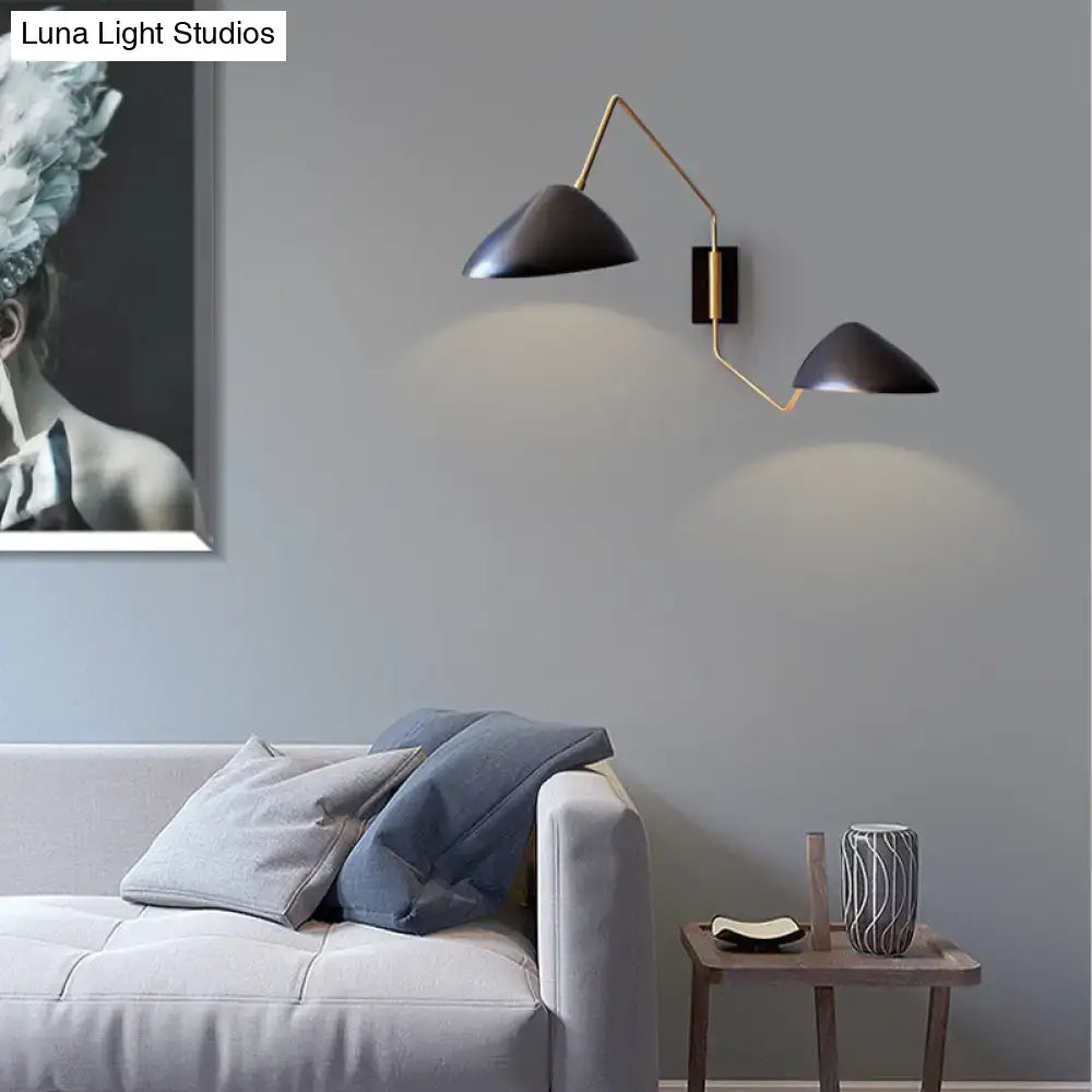 Modern black and brass metal duckbill reading wall light with matte black shades and gold-toned articulated arms
