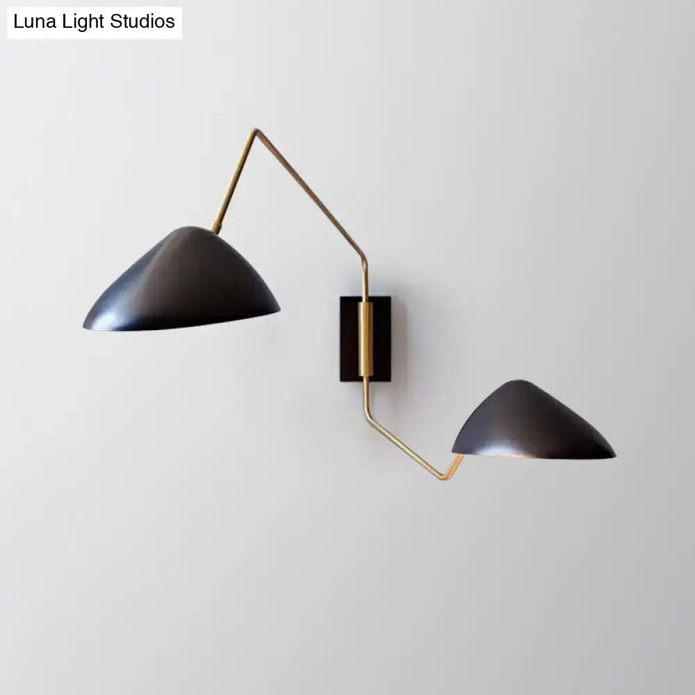 Modern black and brass metal duckbill reading wall sconce with sleek angular double-arm design for bedroom lighting