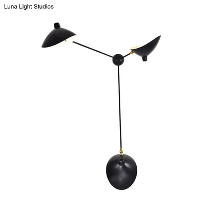 Modern black and brass wall lamp with three sculptural heads and metallic shade featuring adjustable fixture height