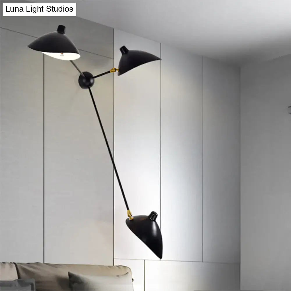 Modern black and brass duckbill wall lamp with double-arm metallic shade and sleek fixture height for living room use