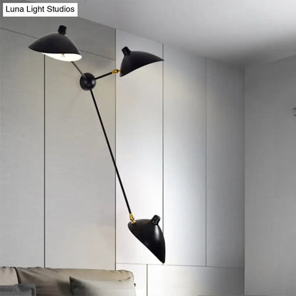 Modern black and brass duckbill wall lamp with double-arm metallic shade and sleek fixture height for living room use