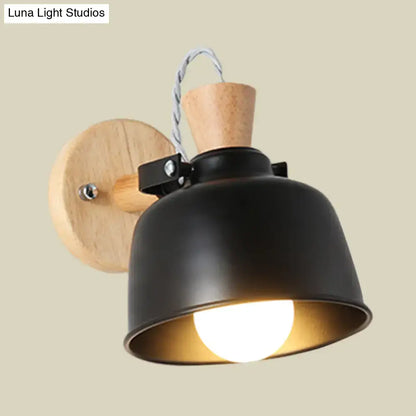 Modern black metal wall light with wooden circular backplate cork accent and exposed bulb in matte shade for bedroom