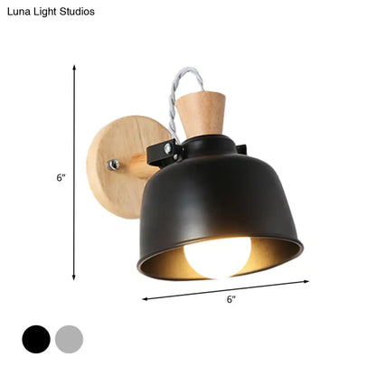 Modern black and brass metal wall light with wooden backplate and adjustable arm for bedroom sconce lighting