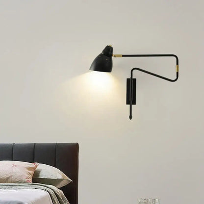 Modern black and brass wall light with articulated arms and backplate width designed for bedroom or studio use with e26 bulb base