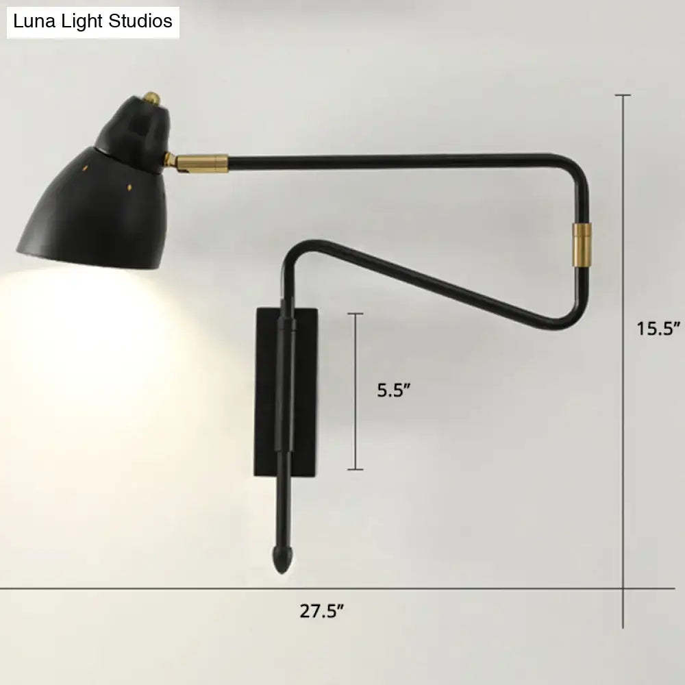 Modern black and brass wall light with curved articulated arm and compact backplate width, suitable for bedroom or studio