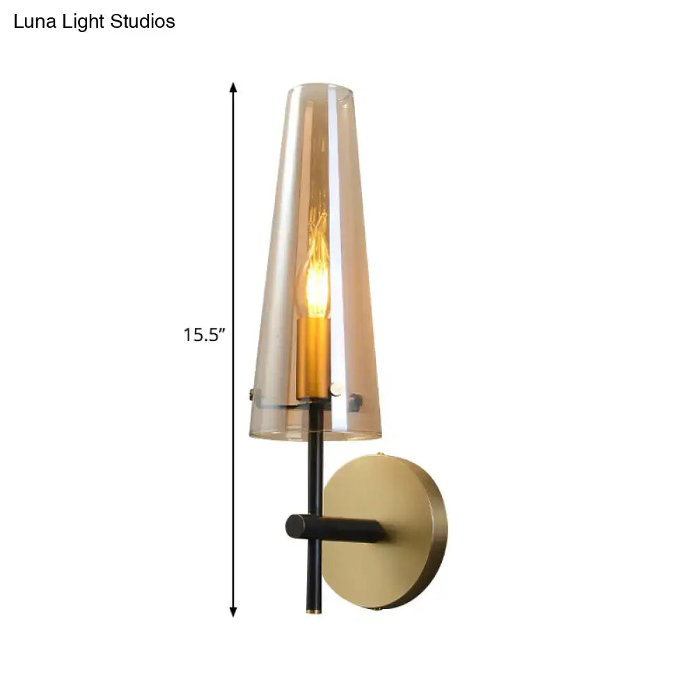 Modern black and brass wall mount light with tall translucent amber glass shade and black metal frame for study room wall light