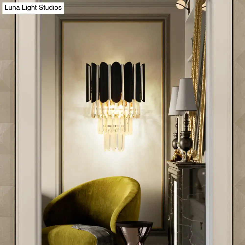Modern black wall sconce with clear crystal cascading accents for bedroom tiered lighting and elegant decor