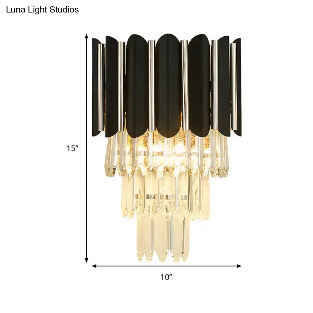 Modern black wall sconce with cascading clear crystal droplets designed as a tiered bedroom light fixture