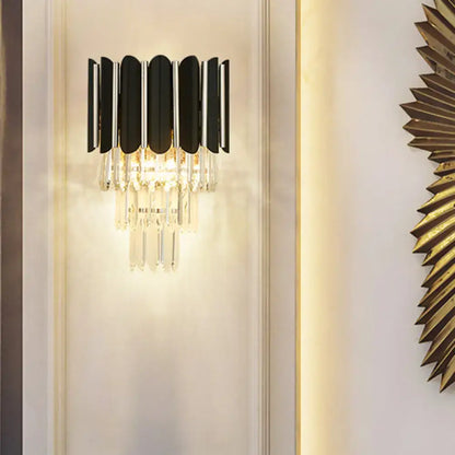 Modern black wall sconce with clear crystal vertical slats and dangling crystals for bedroom lighting