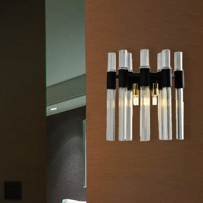 Modern black wall lamp featuring clear glass tubes and metal accents suitable for living room lighting