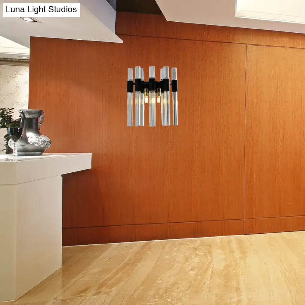 Modern black and clear glass tube wall lamp with five vertical chrome tubes and warm glow for living room lighting