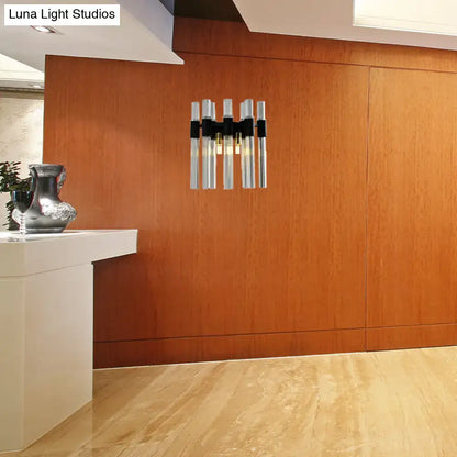Modern black and clear glass tube wall lamp with five vertical chrome tubes and warm glow for living room lighting