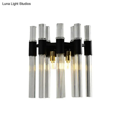 Modern black wall lamp with clear glass tubes and gold-toned fixtures designed for living room use