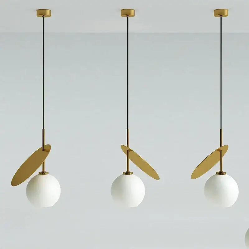 Three modern pendant lights with white glass cherry shades, black cords, and gold accents for dining room decorbites glass cherry