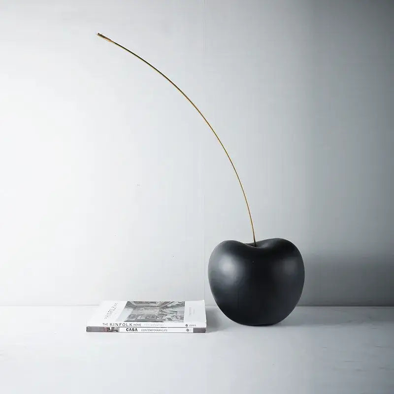 Modern black and gold cherry resin sculpture featuring a black cherry resin body with a slender gold stem for living room decorbites decorbites black cherry