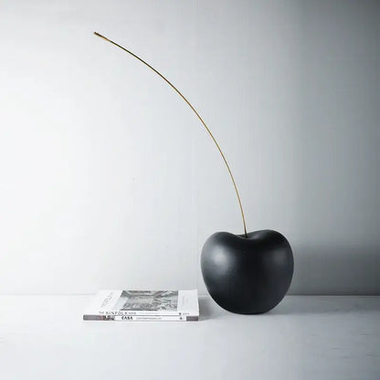 Modern black and gold cherry resin sculpture featuring a black cherry resin body with a slender gold stem for living room decorbites decorbites black cherry