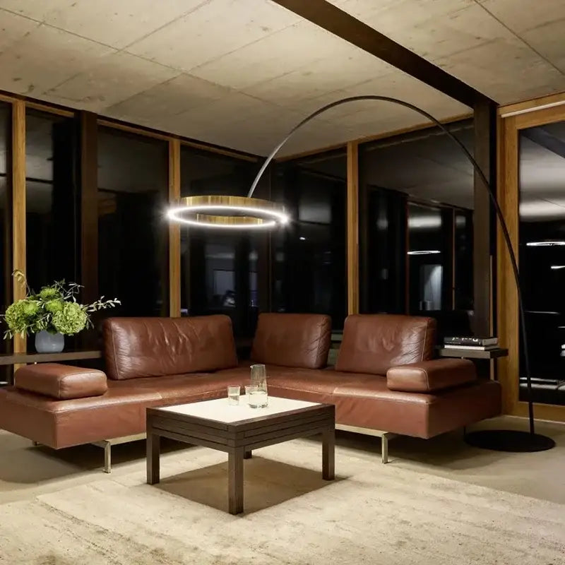Brown leather sectional sofa with minimalist design and integrated armrests complements decorbites circular luminescence led floor lamp