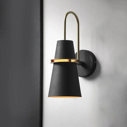 Modern black and gold conical sconce with black matte finish and brass accent ring for dining room wall lighting