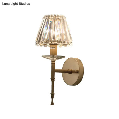 Elegant modern black and gold wall light with brass fixture height and e12 bulb base featuring a faceted crystal shade