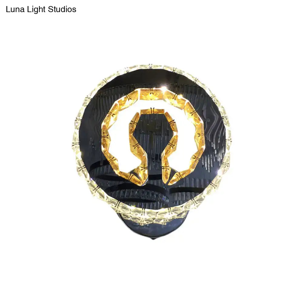 Modern black and gold crystal wall sconce with warm white light and omega-shaped illuminated design for bedroom use