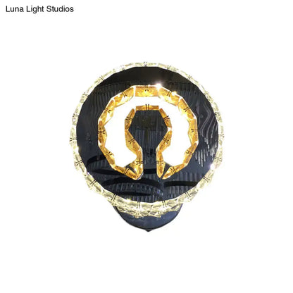 Modern black and gold crystal wall sconce with warm white light and omega-shaped illuminated design for bedroom use