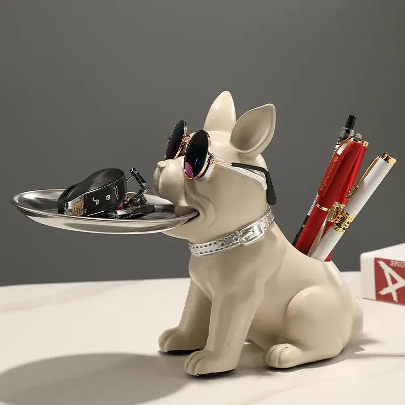 Cream-colored resin decorbites bulldog statue with sunglasses holding a silver tray for keys and glasses