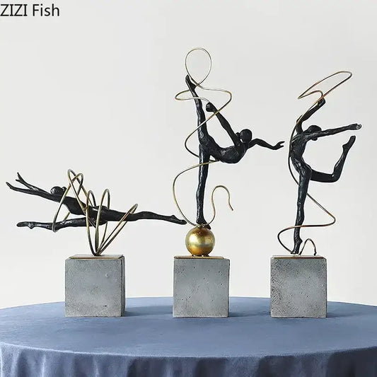 Set of three black metal decorbites gymnast figures with gold wire accents on gray concrete bases for living room decor