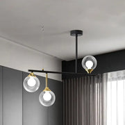 DecorBites™ modern black metal island chandelier with three clear glass ball shades and gold accents for dining room