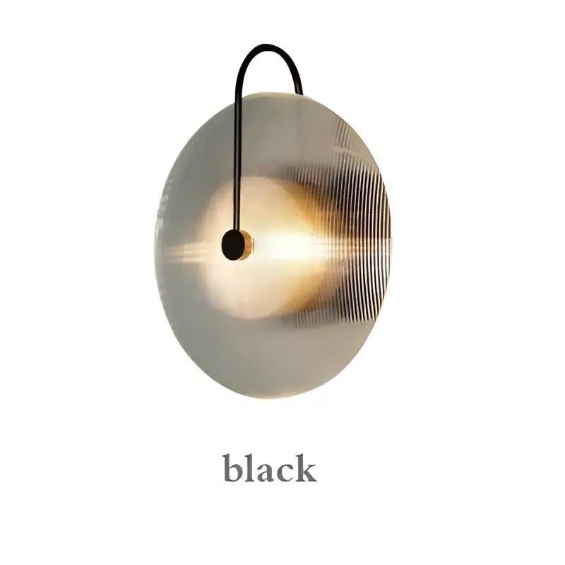 A sleek circular wall lamp with brushed metallic finish and black wire for modern decorbites glass stripe gold bedroom sconce