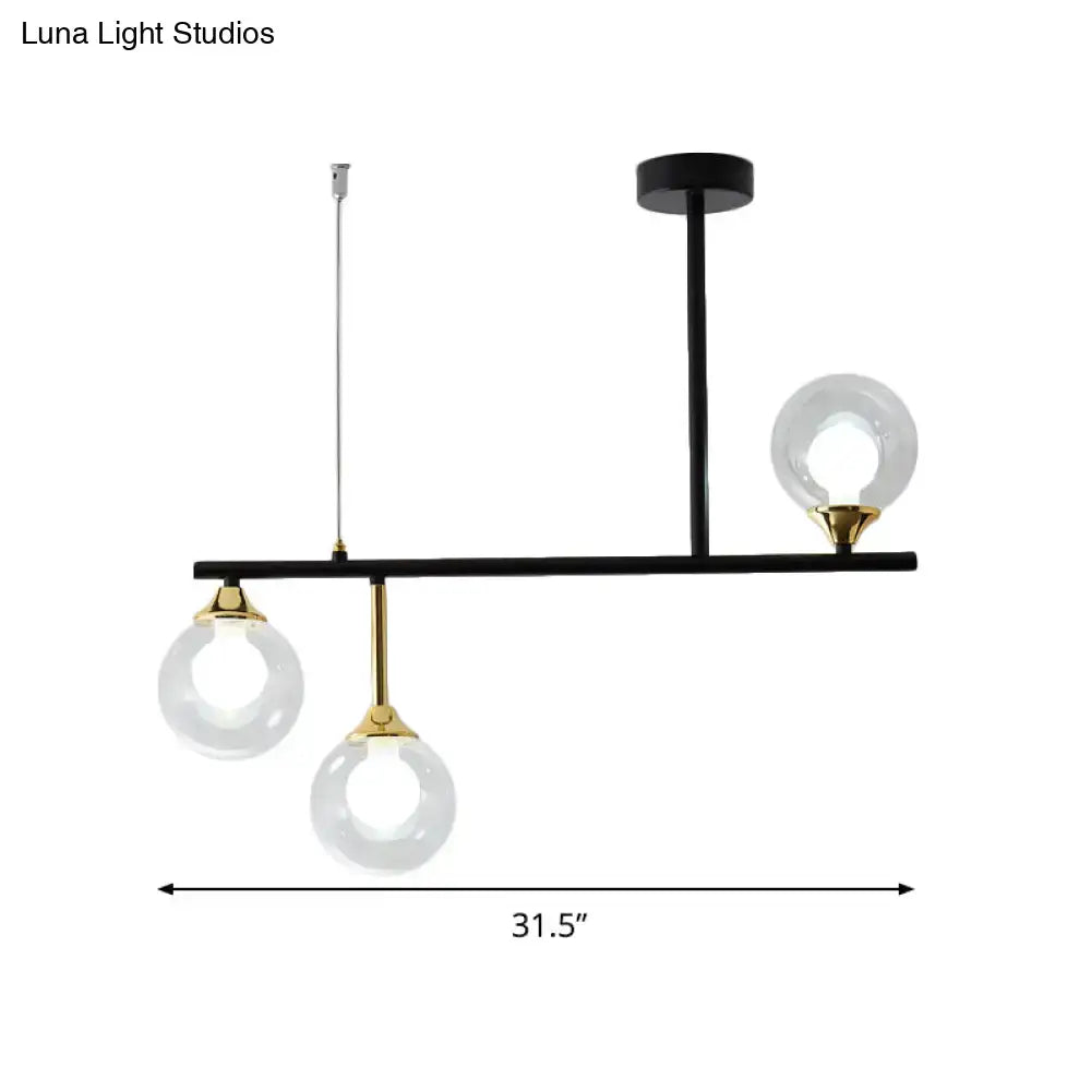 Modern black and gold pendant light fixture with three clear glass globe bulbs for dining room use