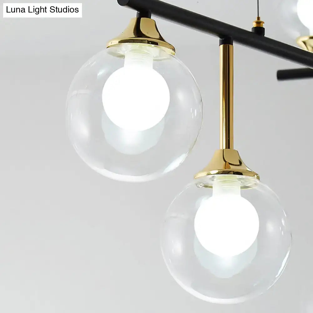 Modern black and gold pendant light fixture with clear glass globes and brass accents for dining room illumination