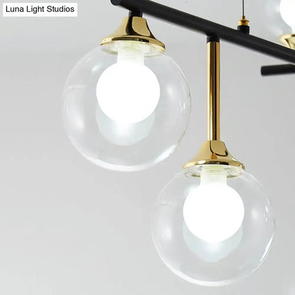 Modern black and gold pendant light fixture with clear glass globes and brass accents for dining room illumination