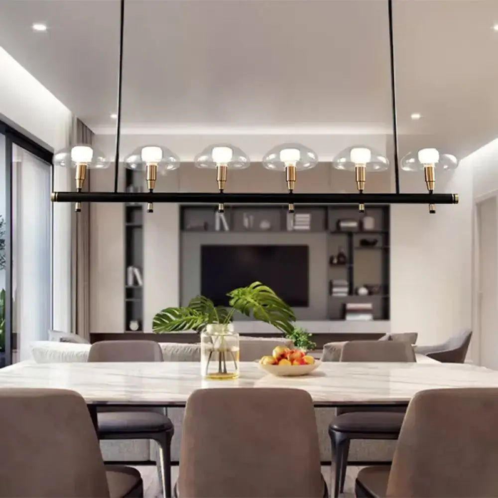 Modern black linear pendant light with five gold fixtures and clear glass shades for restaurant use by decorbites