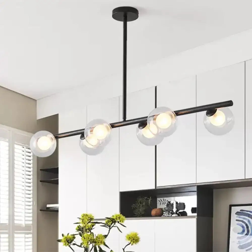 Modern black metal chandelier with five clear glass globe shades featuring light bulbs for dining table illumination