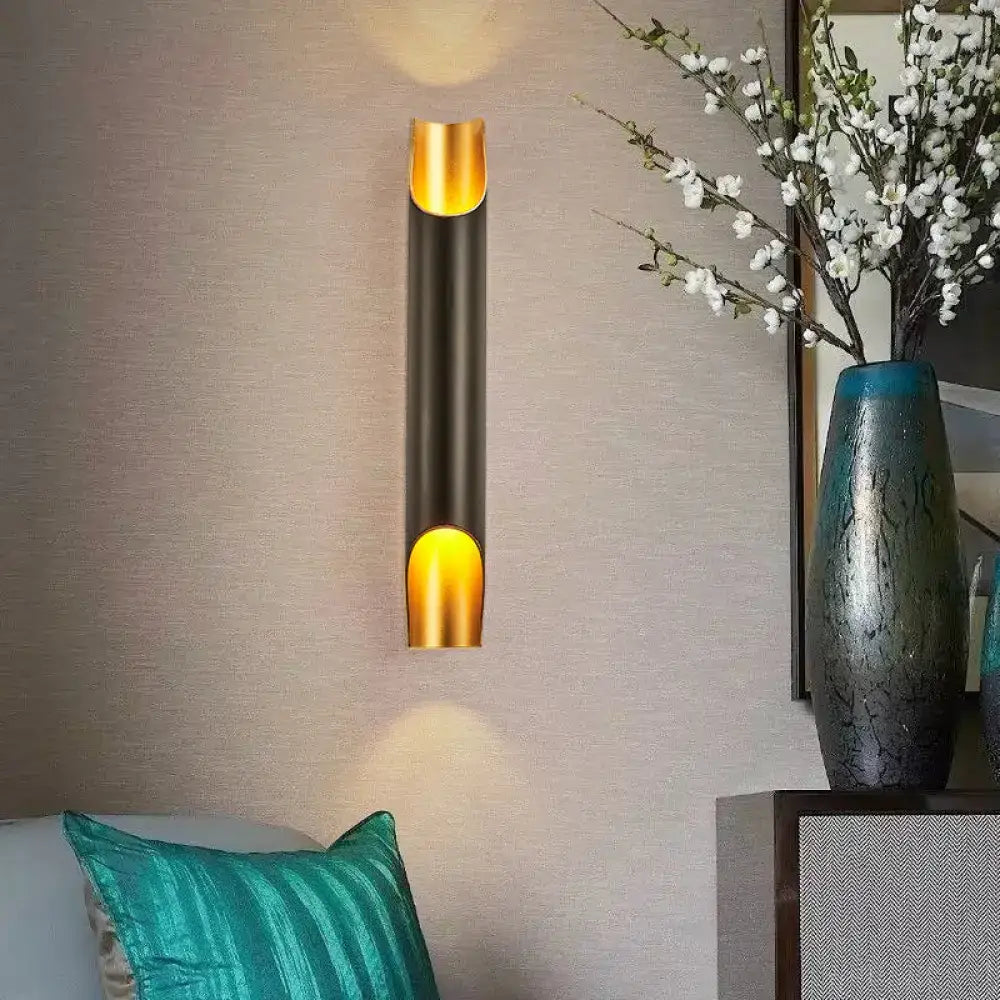 Modern black and gold tubular aluminum wall sconce with sleek cylindrical design for living room lighting