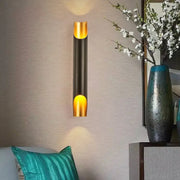 Modern black and gold tubular aluminum wall sconce with sleek cylindrical design for living room lighting