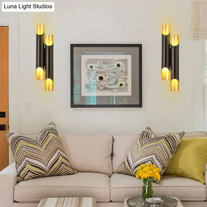 Modern black and gold tubular aluminum wall sconce with cylindrical design for living room lighting