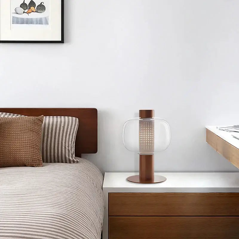 Copper-toned table light with perforated clear glass shade in modern black and gray glass table light decorbites design