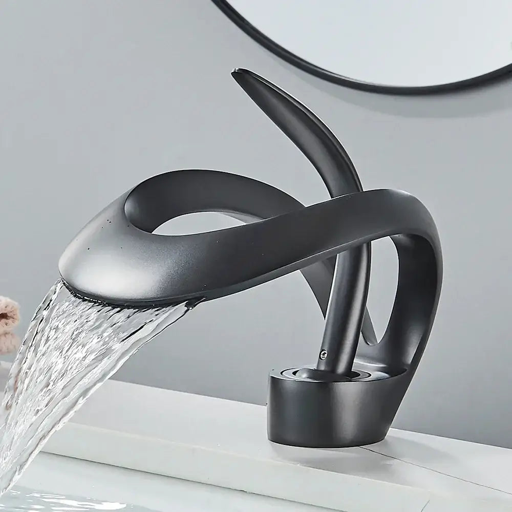 Modern black and grey waterfall mixer tap with matte finish and sleek sculptural design for bathroom basin faucet