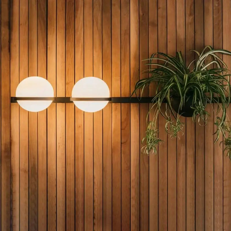 Modern black and white acrylic ball wall lights featuring two frosted white acrylic globes on a minimalist black bar