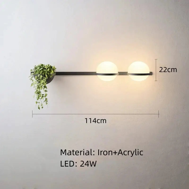 Modern black iron wall lights with white acrylic ball shades and built-in hanging plant holder for bedroom use