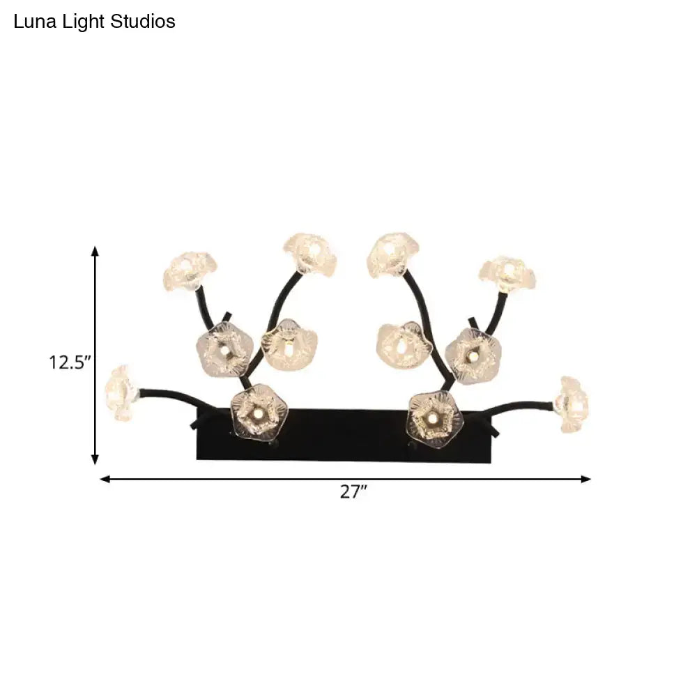Modern black metal wall light with delicate branching arms and blossom clear glass flower-shaped fixtures for bedroom