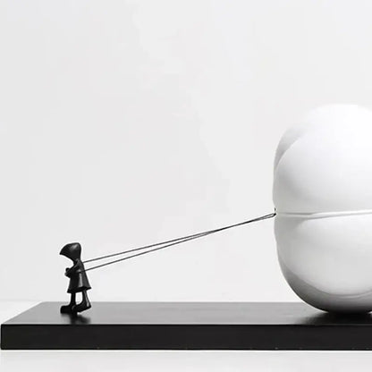 Modern black and white cartoon balloon man sculpture featuring a child figurine pulling a spherical balloon for decor