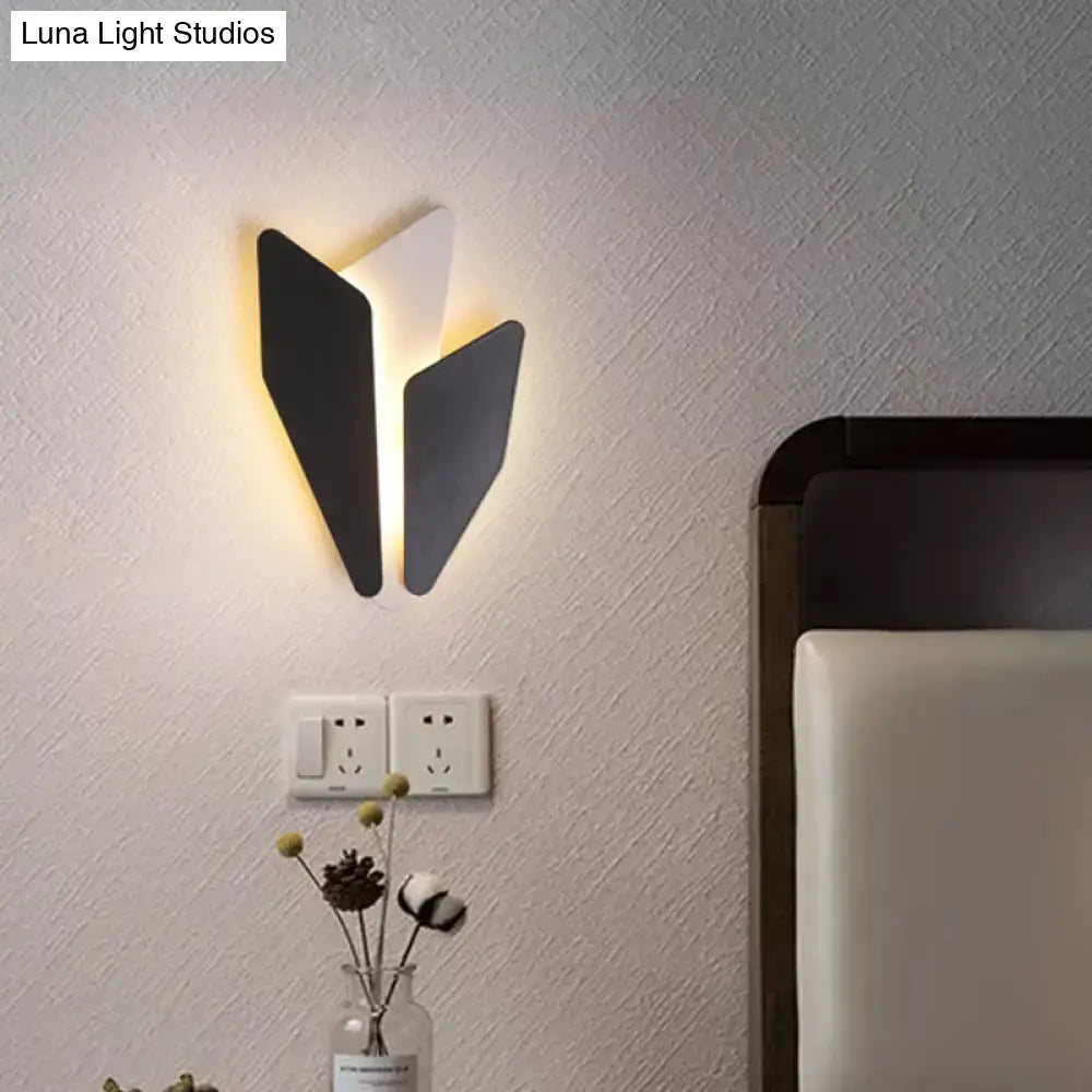 Modern black and white geometric wall light fixture with a sleek angular design for living room use