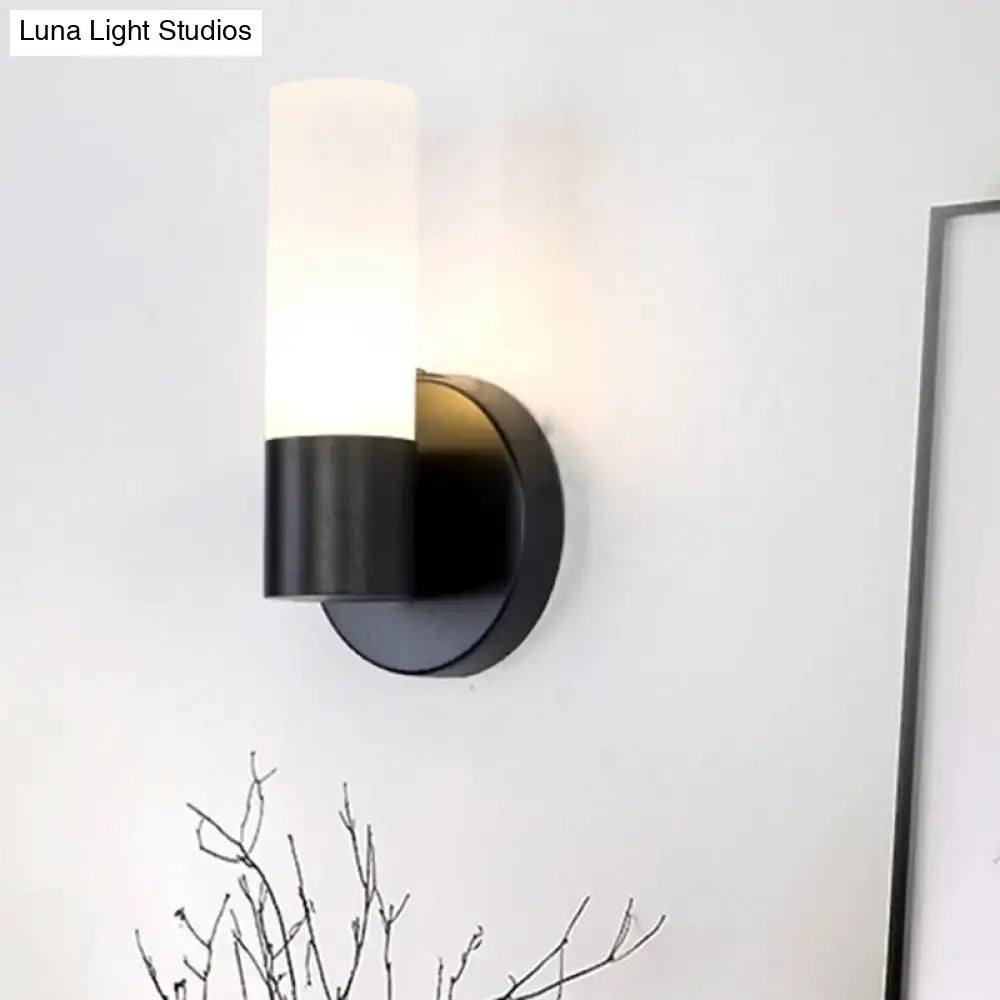 Modern black and white glass sconce lamp featuring a cylinder white glass shade and matte finish for bedroom wall light