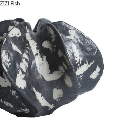 Modern black and white ceramic starfruit coral sculpture with organic shell-like folds for bedroom decor