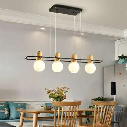 Modern black orb island pendant light with frosted glass hanging globes and wooden accents for interior decor