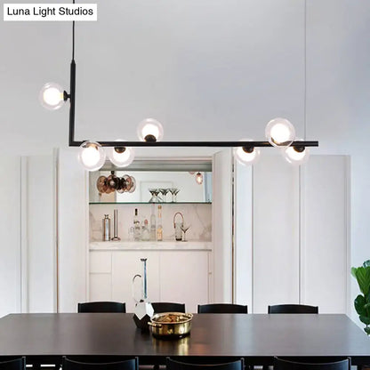 Modern black angle arm chandelier with clear glass globe bulbs designed as a kitchen island pendant light